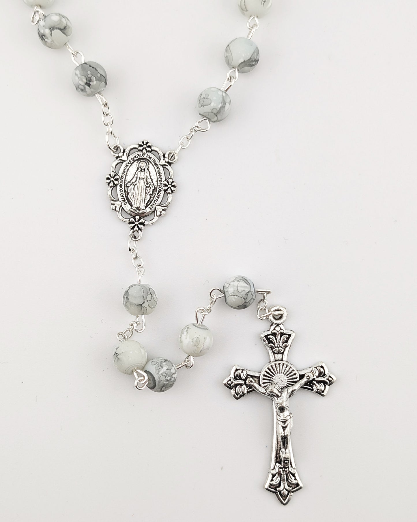 Silver rosary with gray beads on a white background