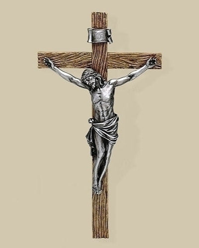Metallic crucifixion sculpture on a beige background