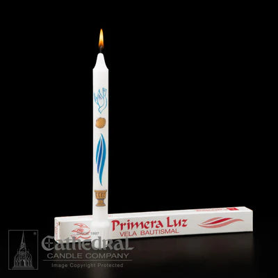 White candle with decorative elements and packaging labeled 'Primera Luz' on a black background.