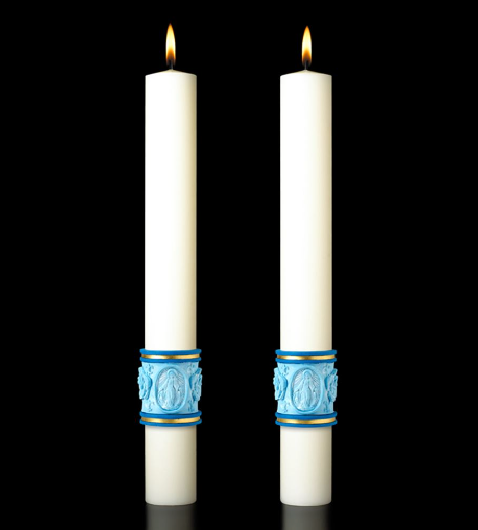 Two white candles with blue decorative bands on a black background