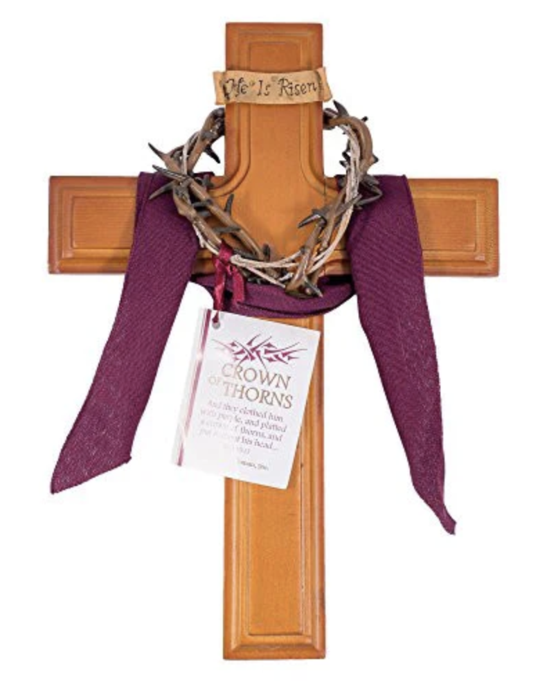 Wooden cross with a crown of thorns and purple fabric on a white background
