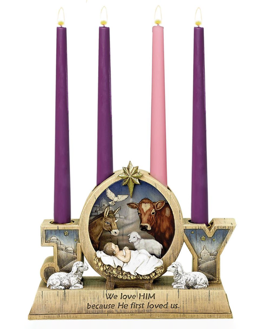 Advent wreath with nativity scene and colorful candles on a white background