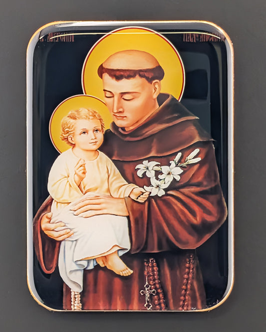 Decorative tin with an illustration of a religious figure holding a child on a dark background