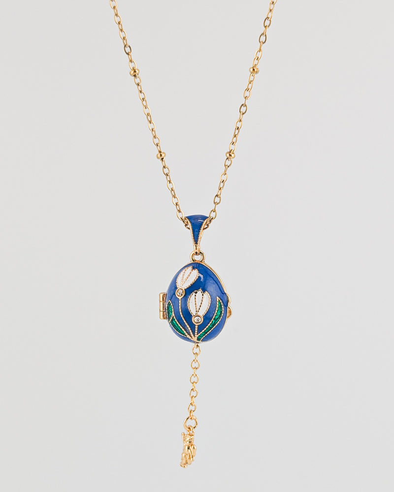 Blue pendant necklace with gold chain on a light gray background