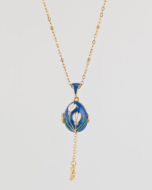 Blue pendant necklace with gold chain on a light gray background