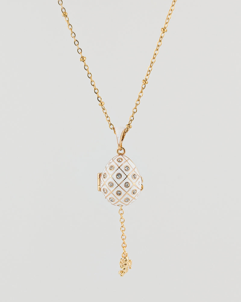 Gold necklace with a diamond pendant on a light gray background