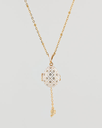 Gold necklace with a diamond pendant on a light gray background