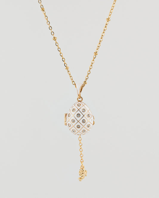 Gold necklace with a diamond pendant on a light gray background