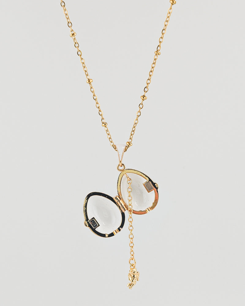 Gold necklace with a pendant on a light gray background