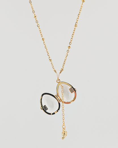 Gold necklace with a pendant on a light gray background