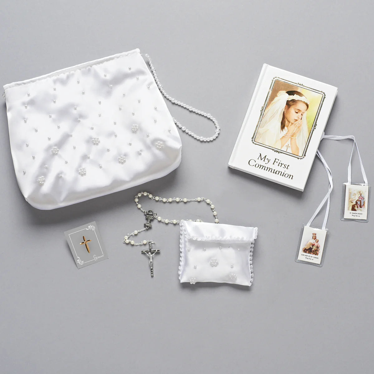 First Communion kit with rosary, prayer cards, and pouch on a gray background