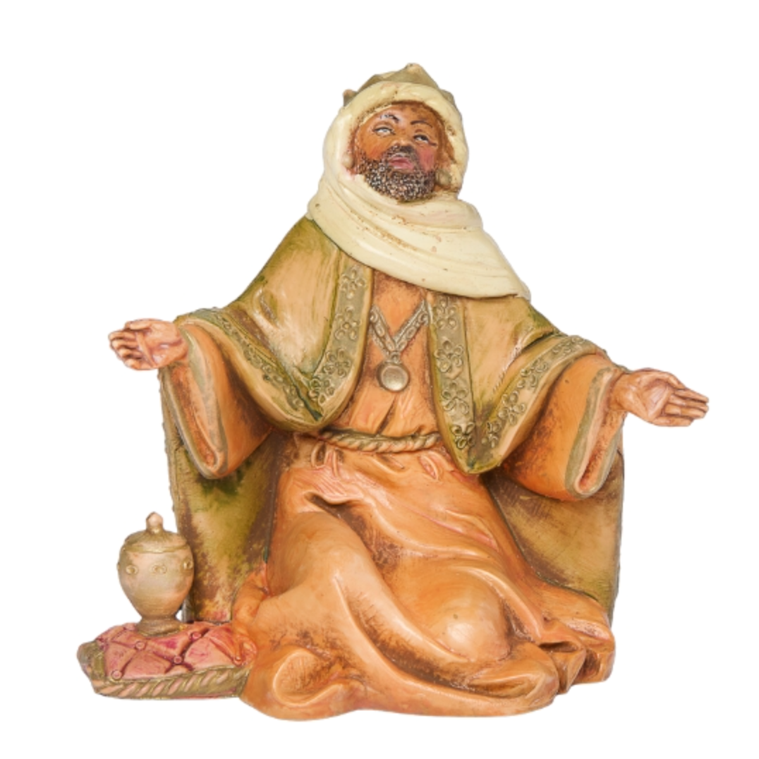 Statue of a seated figure in traditional attire with a white background