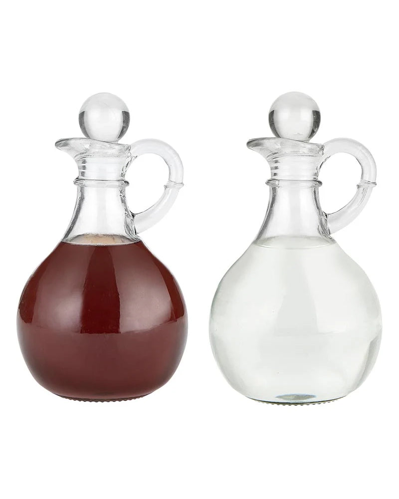 Two glass decanters, one filled with a red liquid and the other with a clear liquid, on a white background.