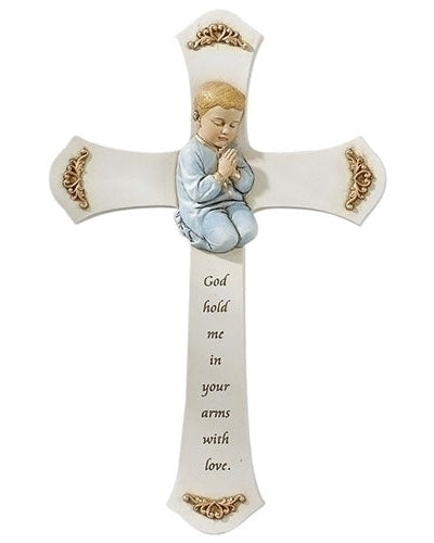 A white cross with a resin figurine of a boy praying on it. The cross has text that reads 'GOD HOLD ME IN YOUR ARMS WITH LOVE'.