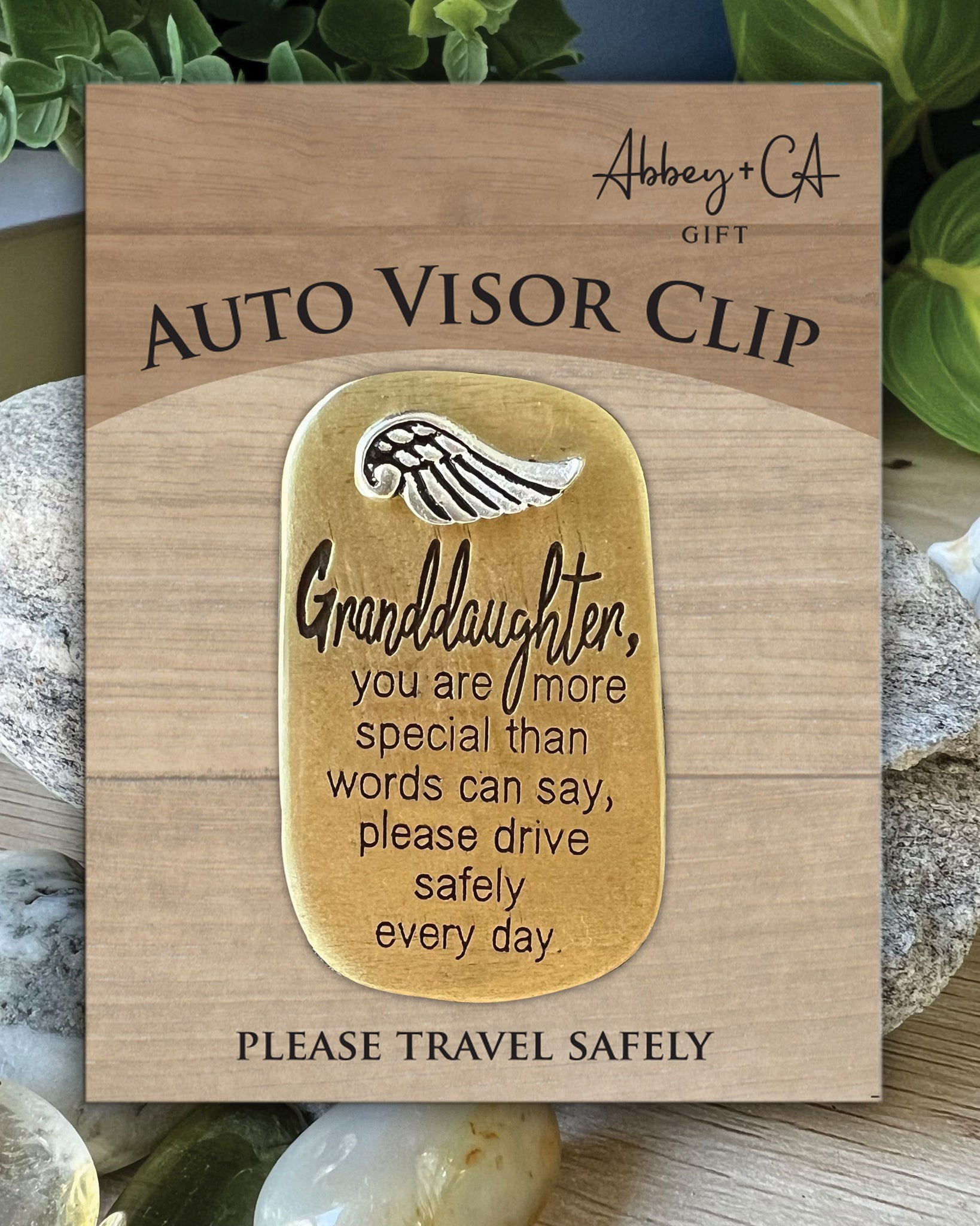 Wooden card with gold tag and text message, placed on a natural background.