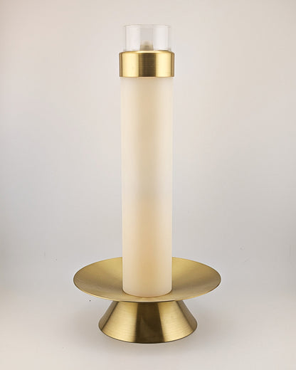 Gold candle holder with a white candle on a light gray background
