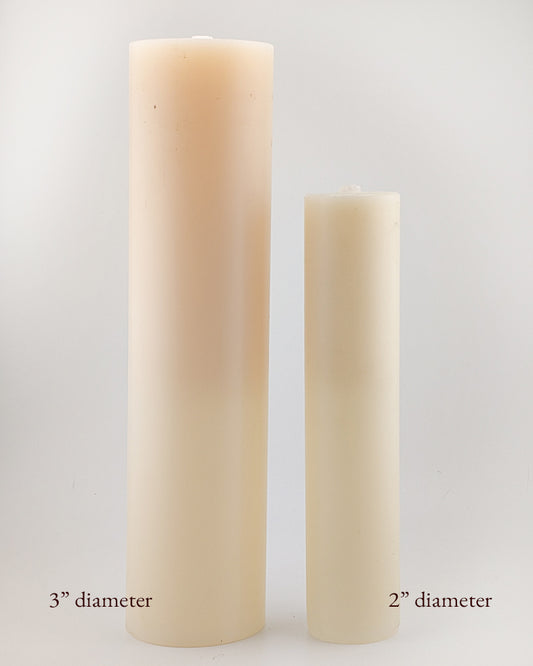Two beige candles of different diameters on a white background