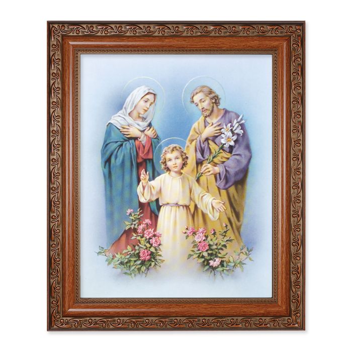 A framed print of the Holy Family, featuring dark mahogany frame with Acanthus-leaf detailing, containing an image of Mary, Joseph, and baby Jesus.