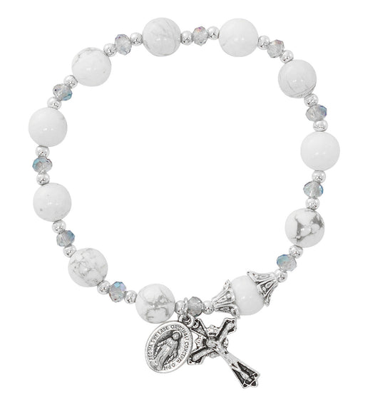 White beaded bracelet with a cross and religious charm on a white background