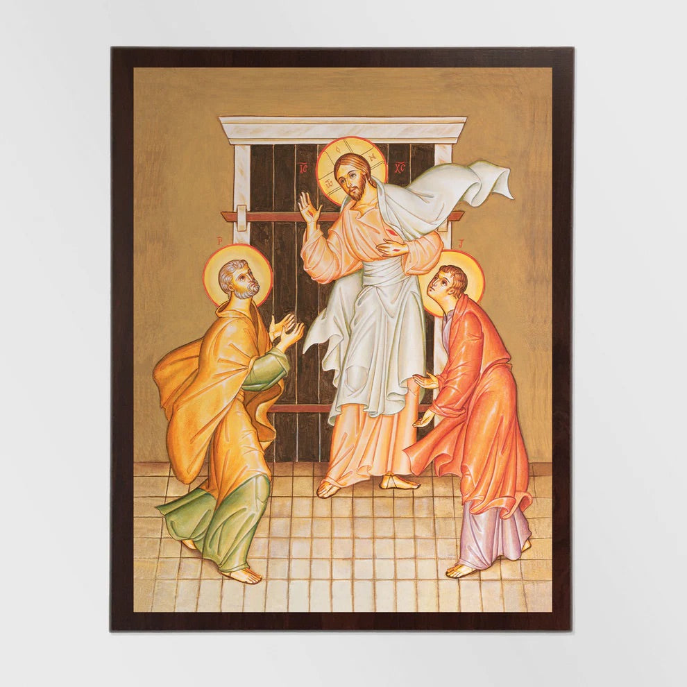 Framed artwork depicting a religious scene with three figures on a beige background