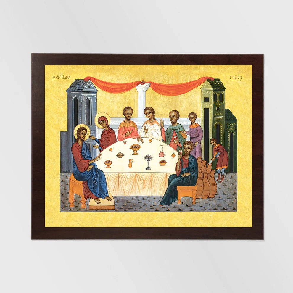 Framed artwork depicting a religious scene with figures around a table on a yellow background.