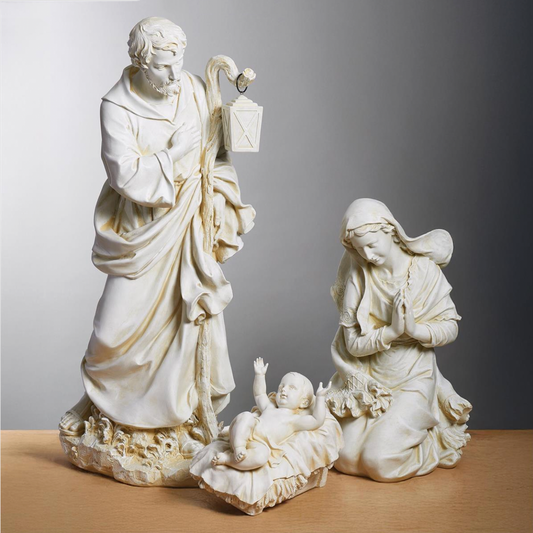 A three-piece ivory-colored resin nativity set featuring Saint Joseph, the Virgin Mary, and baby Jesus in a realistic studio setting.