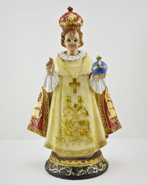 Decorative figurine of a person in religious attire with gold, red, and white colors on a white background