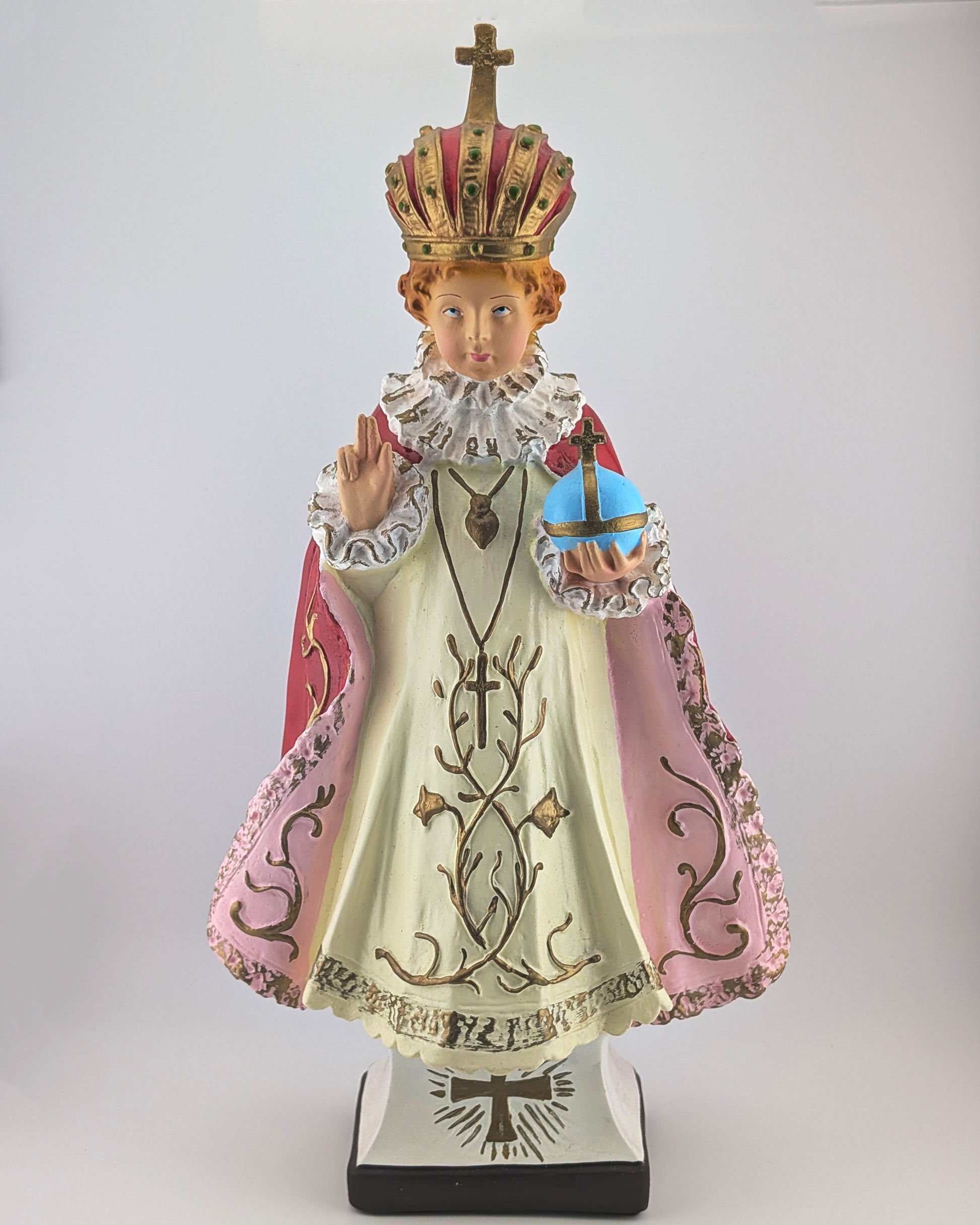 Statue of a religious figure in ornate clothing with a crown on a white background