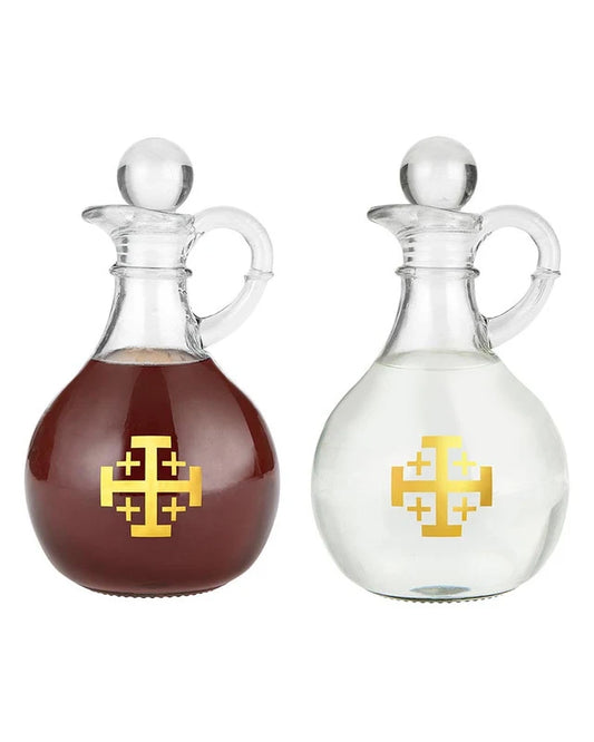 Two glass bottles with a gold cross design on a white background