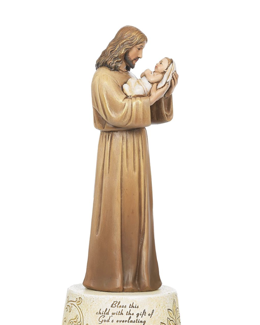 Statue of a robed figure holding a child on a white background