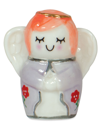 Small ceramic angel figurine with pink hair and a purple outfit on a white background