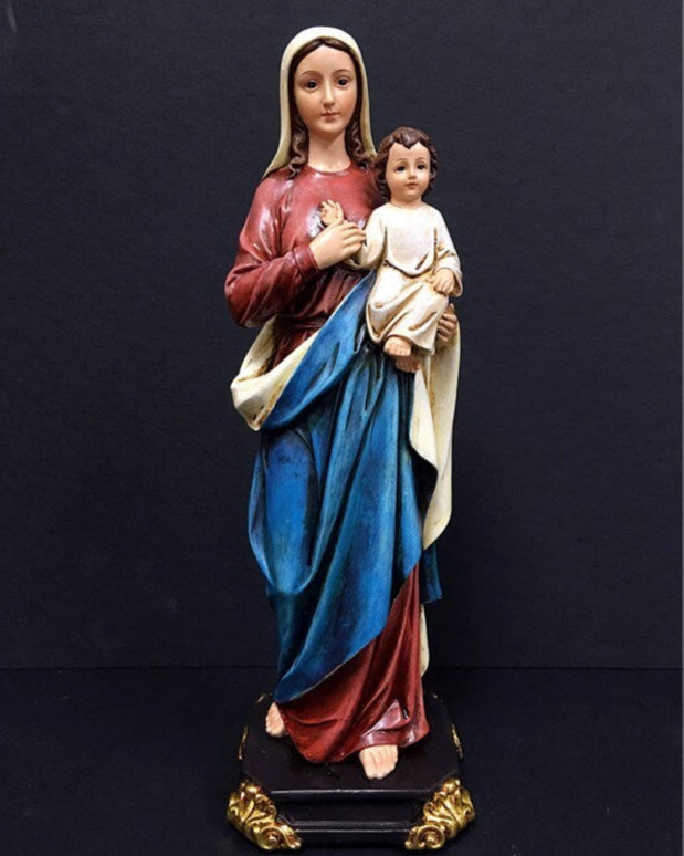 Statue of a woman holding a child against a black background