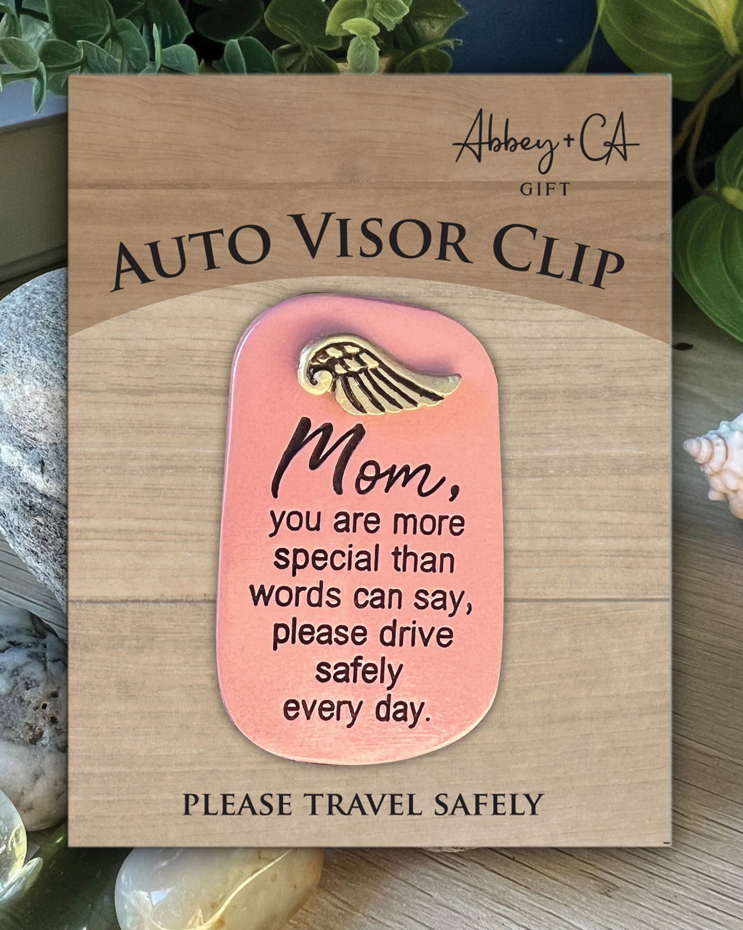 Auto visor clip with motivational message on a wooden card, featuring the brand 'Abbey & Co'.