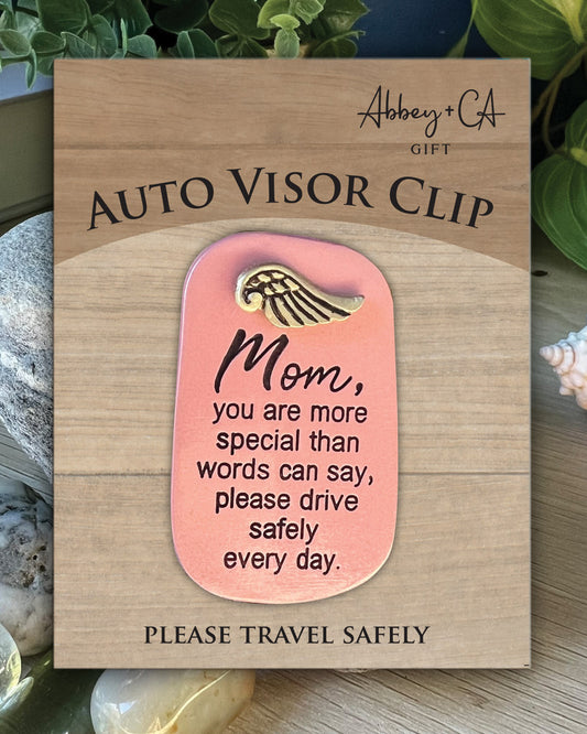 Auto visor clip with motivational message on a wooden card, featuring the brand 'Abbey & Co'.