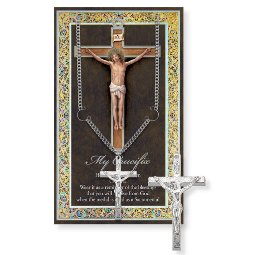 Silver crucifix necklace with ornate packaging featuring a depiction of Jesus on the cross.