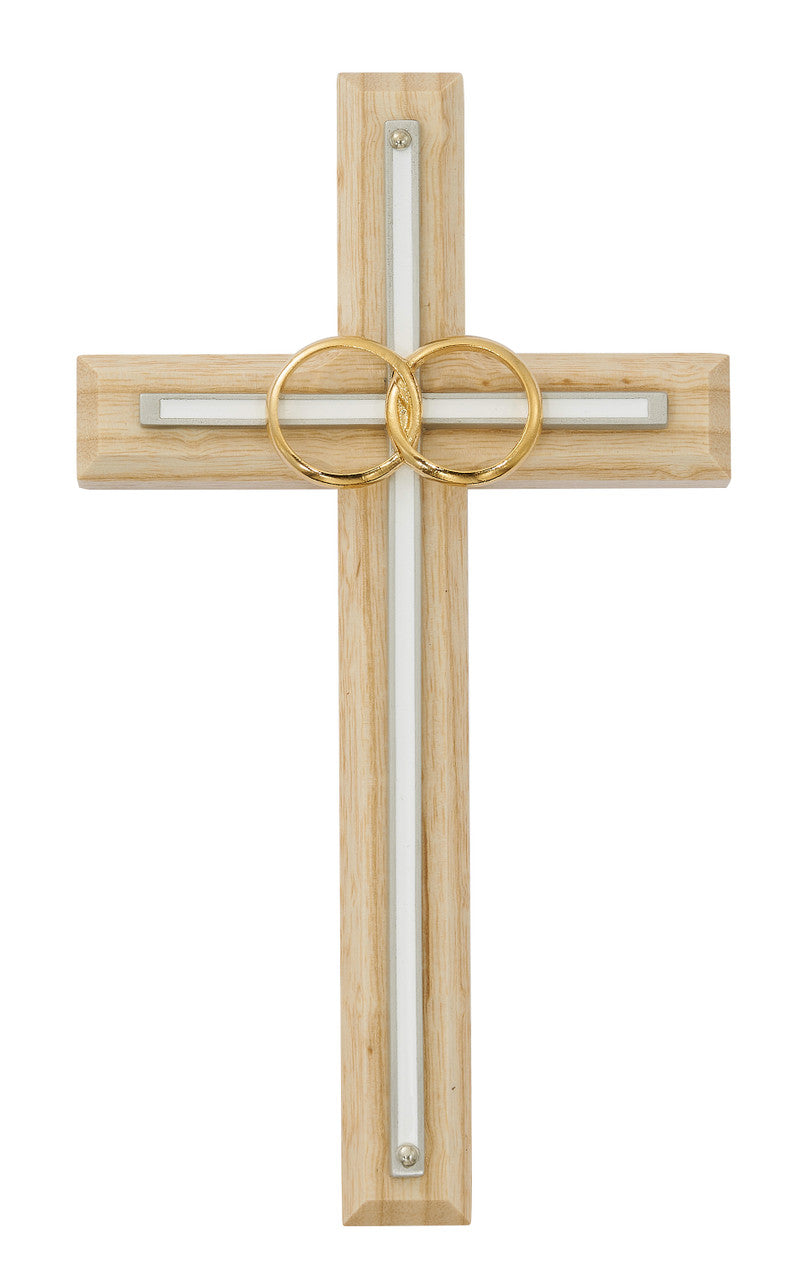 A stained oak wood cross with white enamel inlay and brass wedding rings.