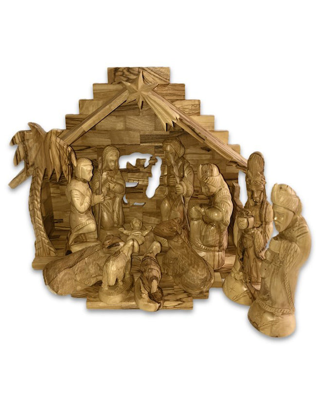 Wooden nativity scene with figures and stable on a white background
