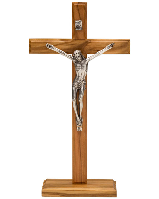 A wooden Christian cross with a metallic silver corpus of Jesus Christ, featuring a natural wood finish and a small 'INRI' plaque at the top.