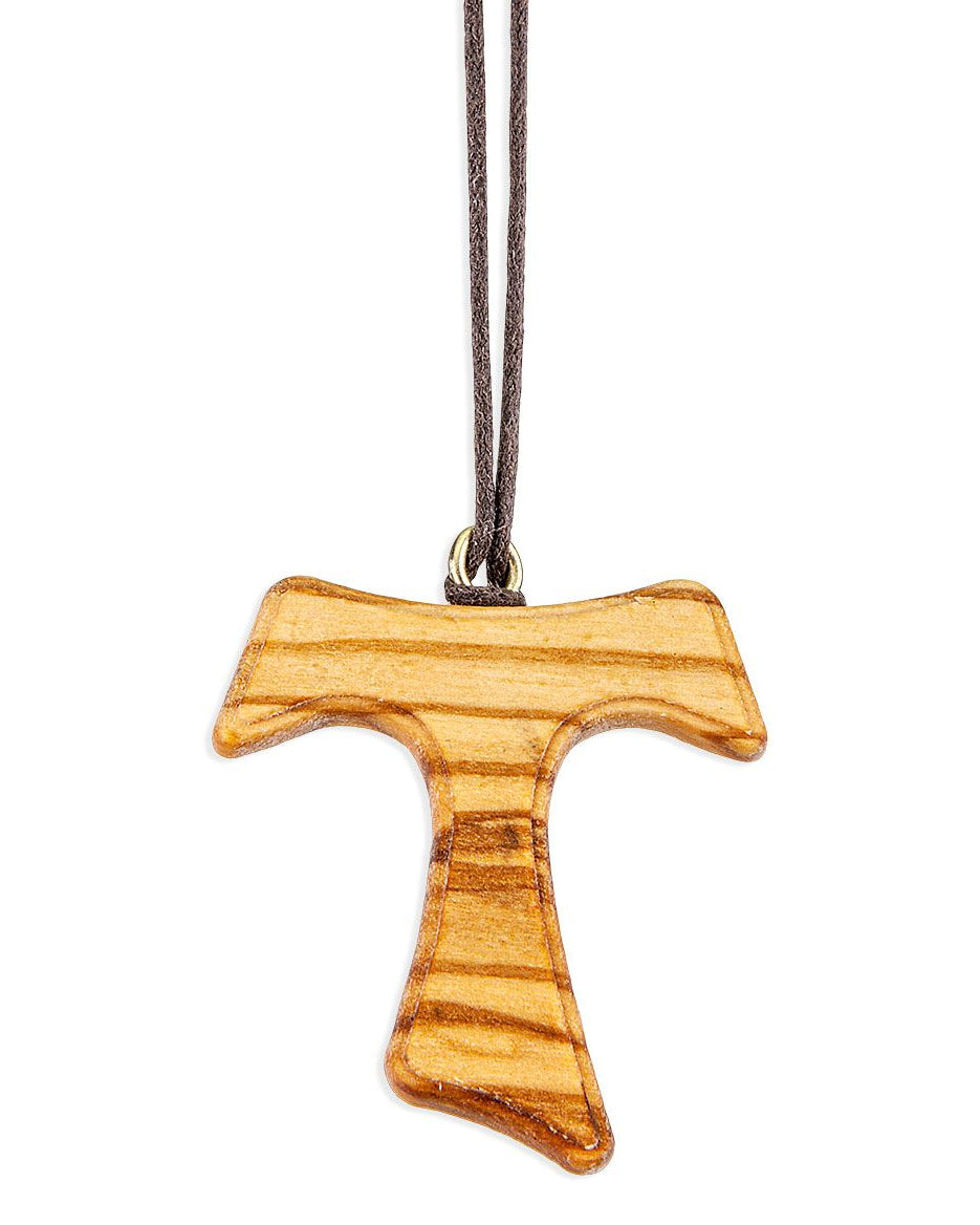 Wooden cross pendant on a cord against a white background