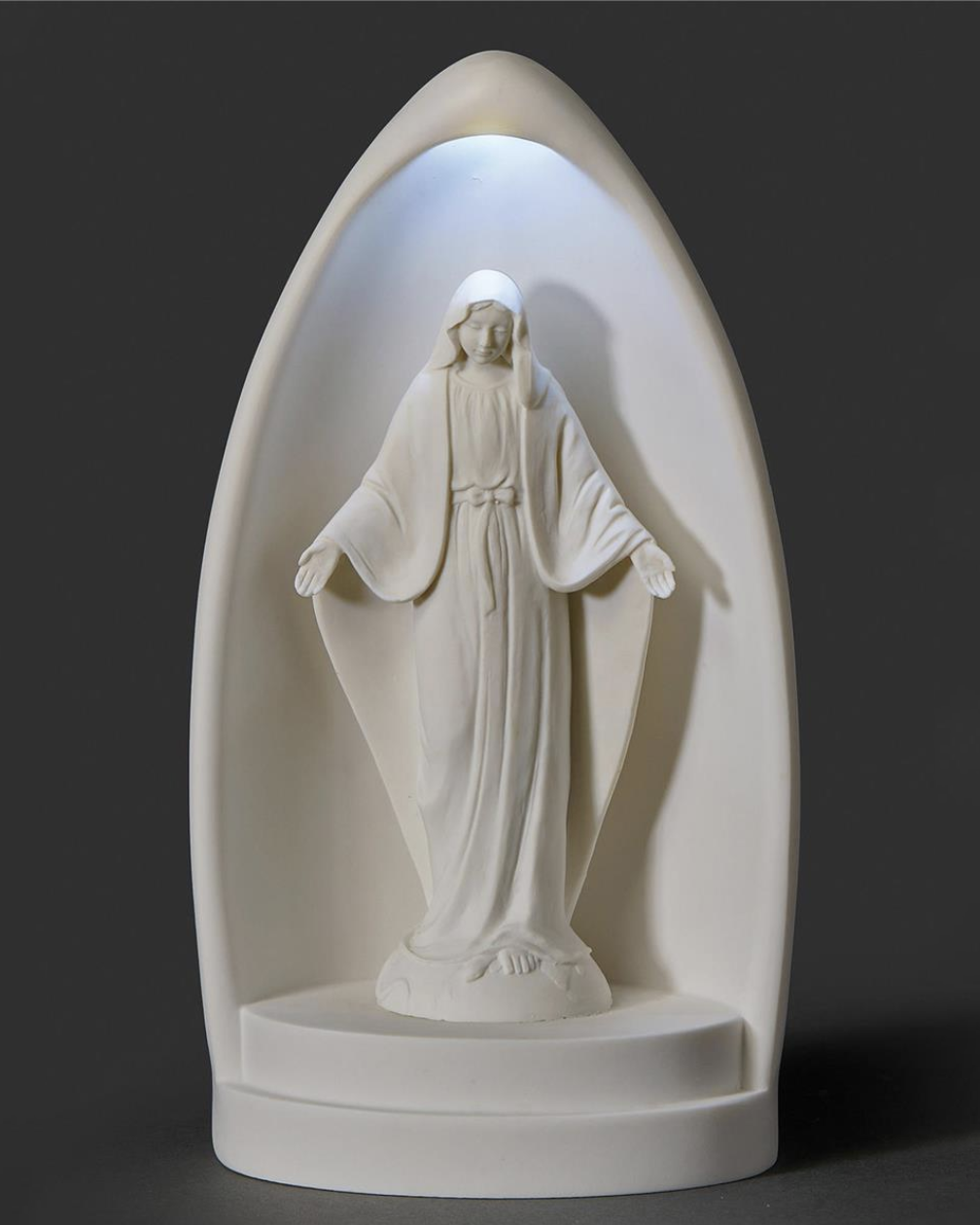 Statue of a religious figure in a white niche with a dark background