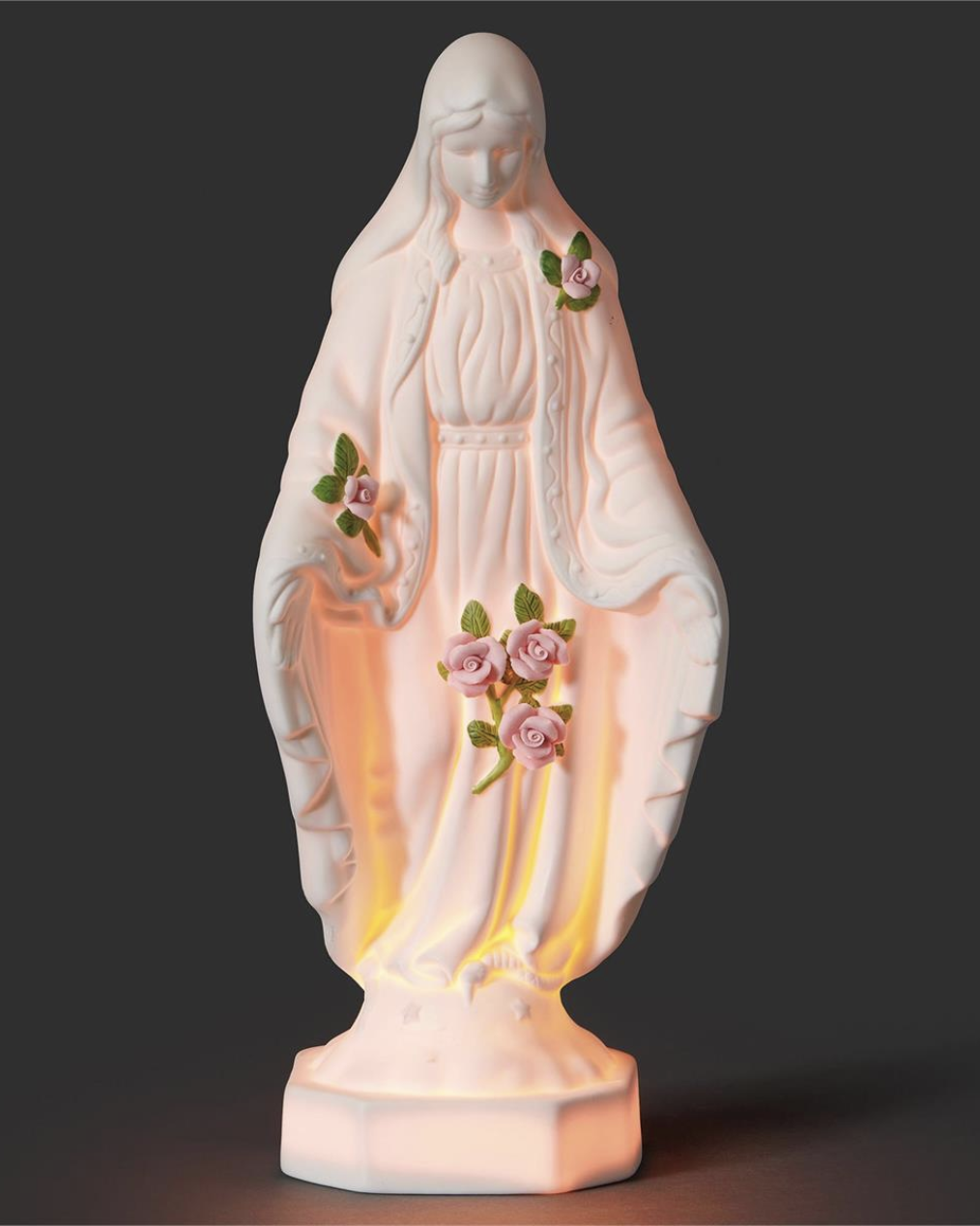 Statue of a religious figure with floral decorations on a dark background