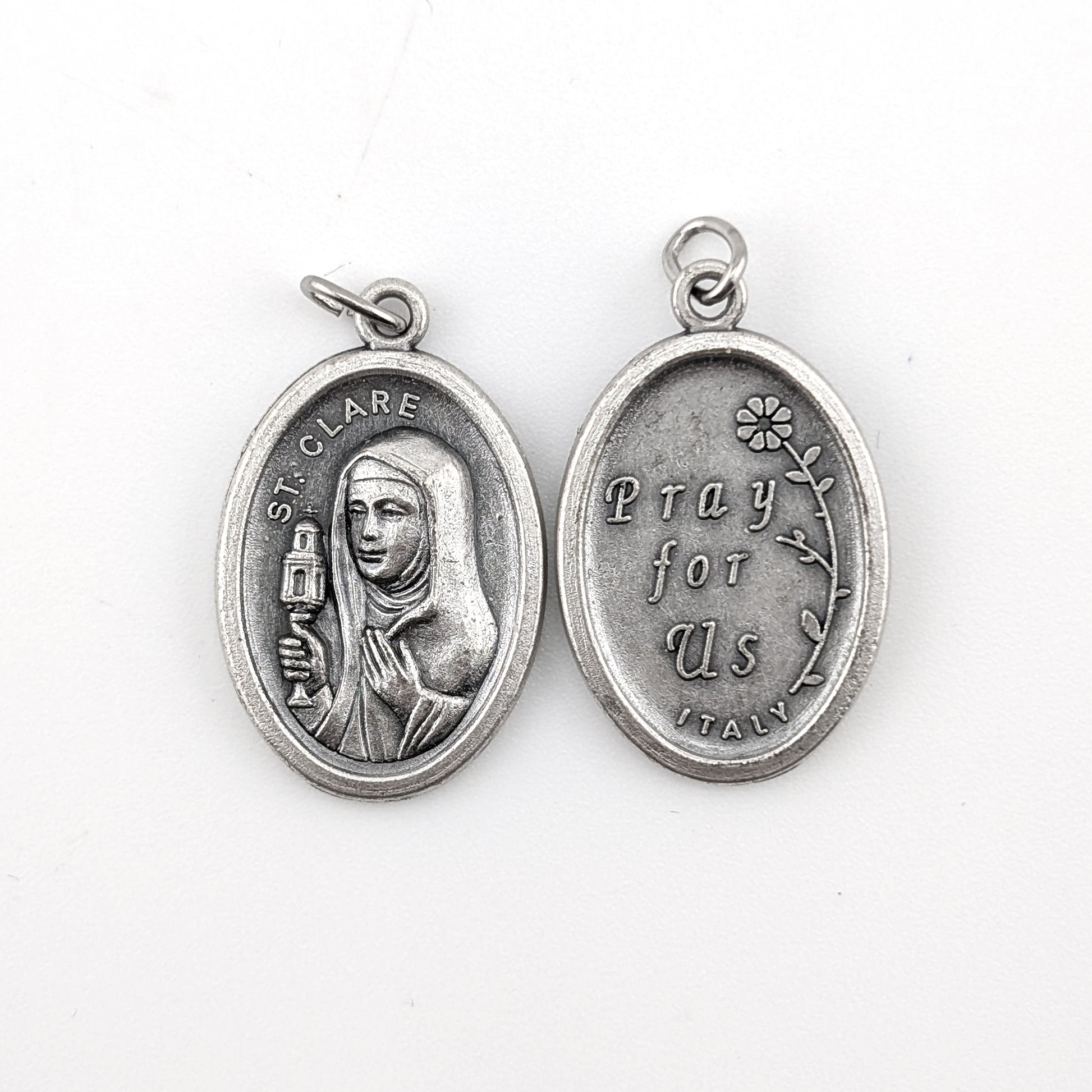 Silver religious pendant with a portrait and text on a white background