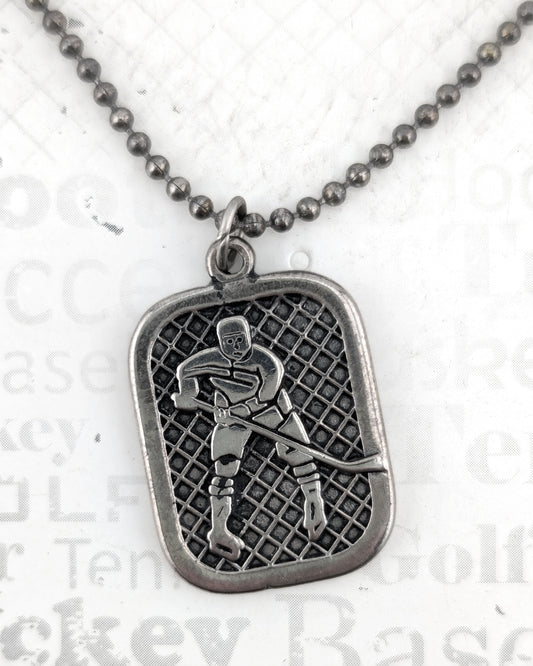 Silver pendant with a hockey player design on a chain against a white background.