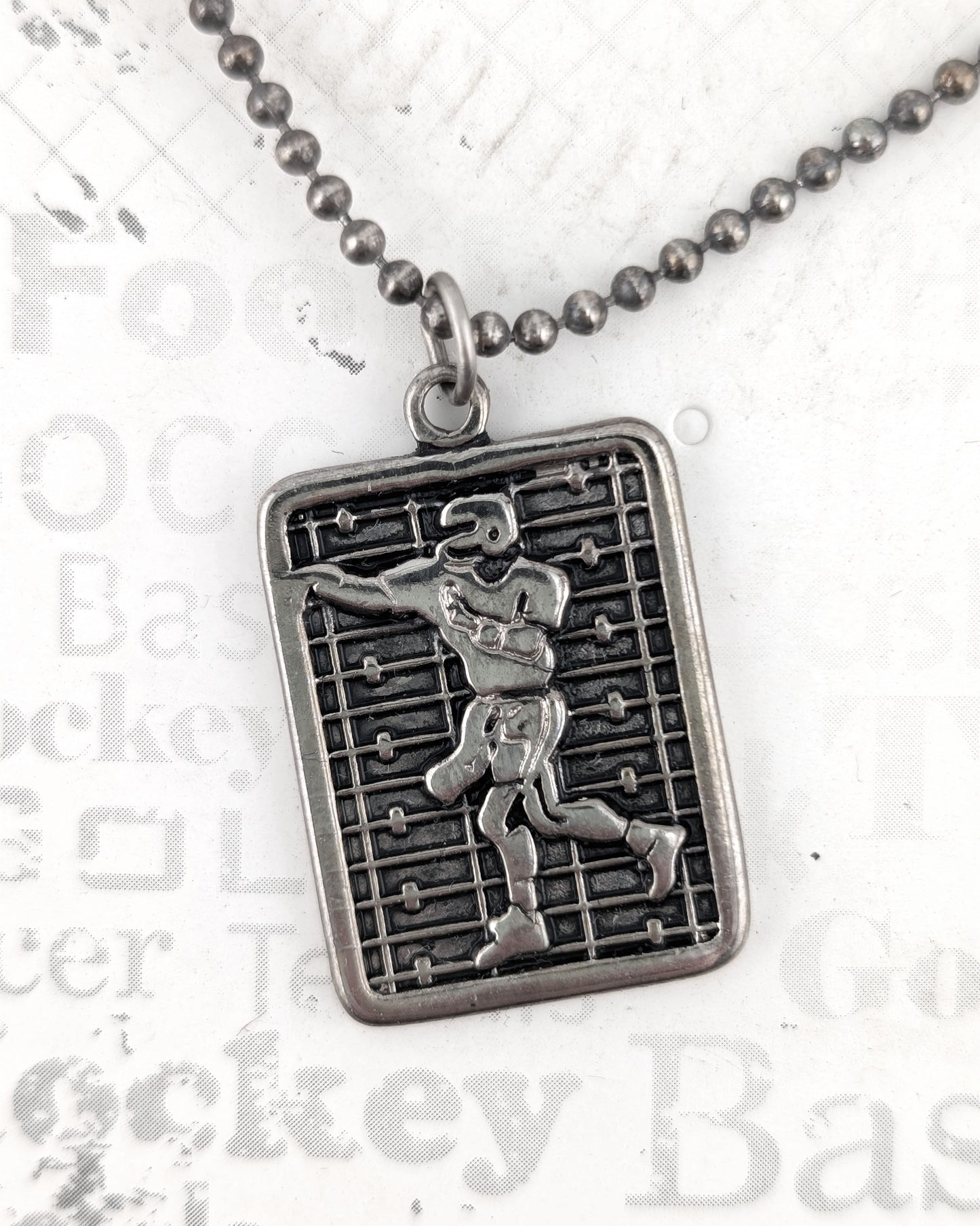 Silver pendant necklace with a detailed design on a white background