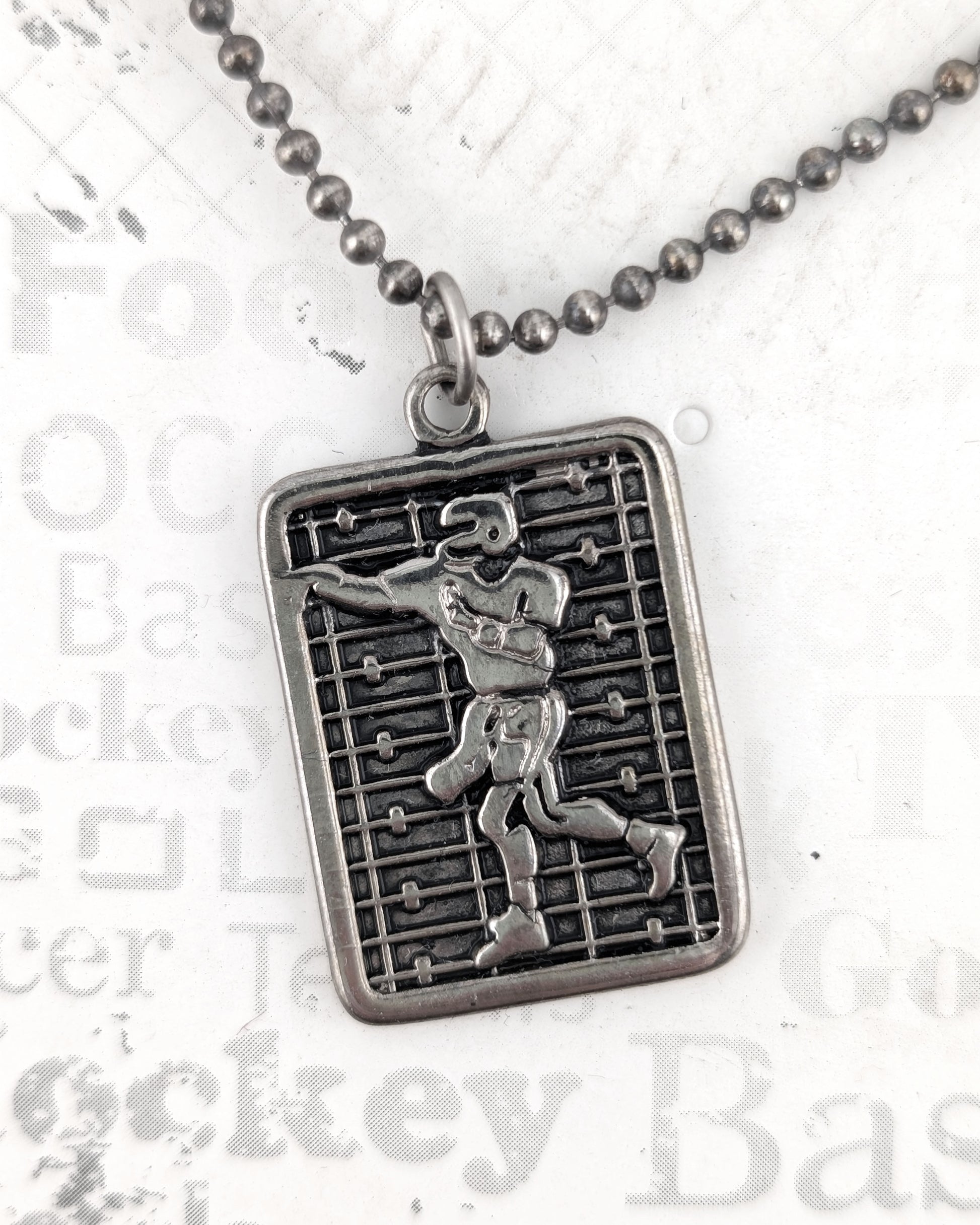 Silver pendant necklace with a detailed design on a white background
