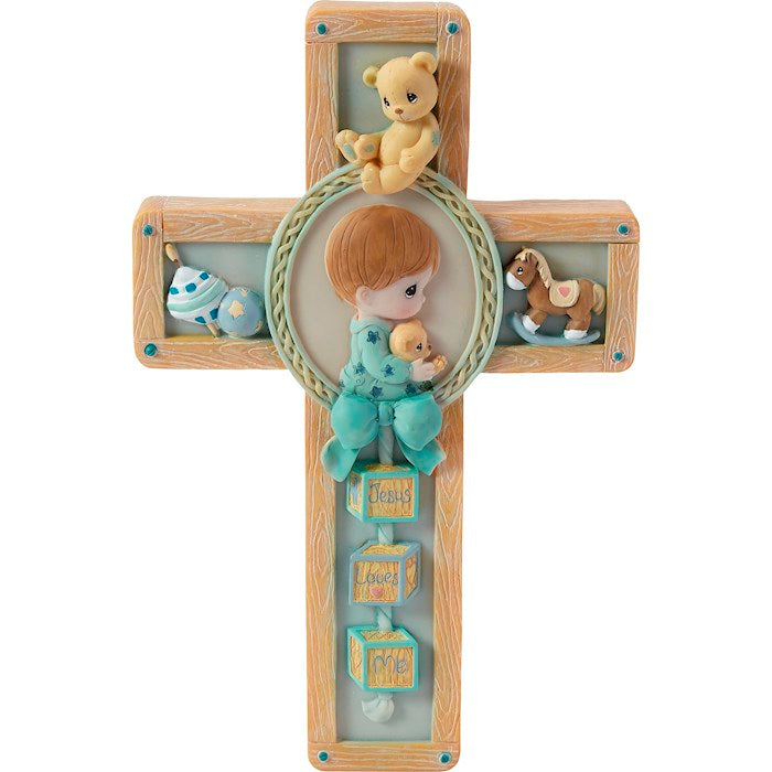 A resin cross with a hand-painted scene of a boy and a teddy bear, surrounded by various small toys and a bear-themed shirt.