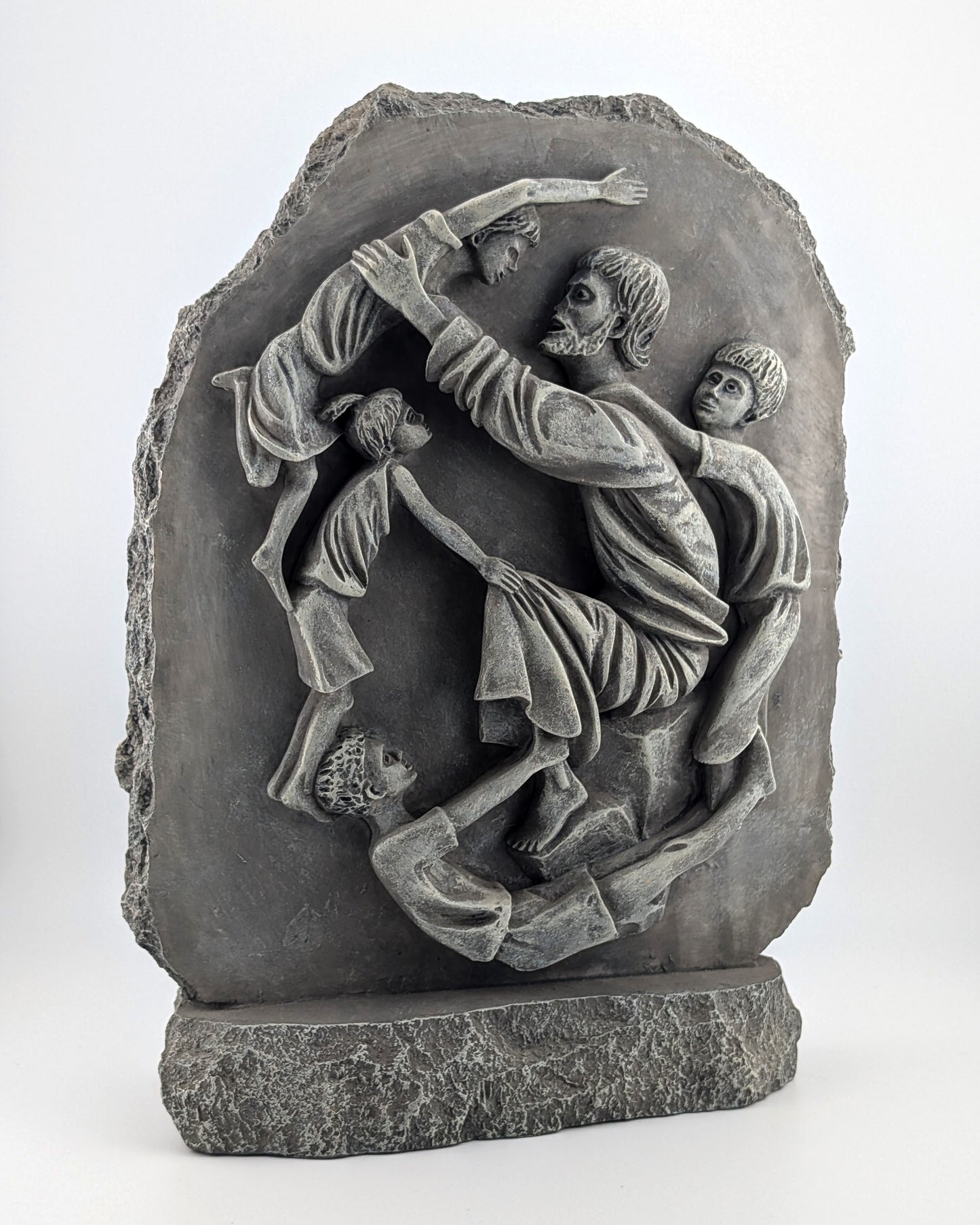 Stone sculpture depicting a scene with people, possibly a historical or mythological event, on a white background.