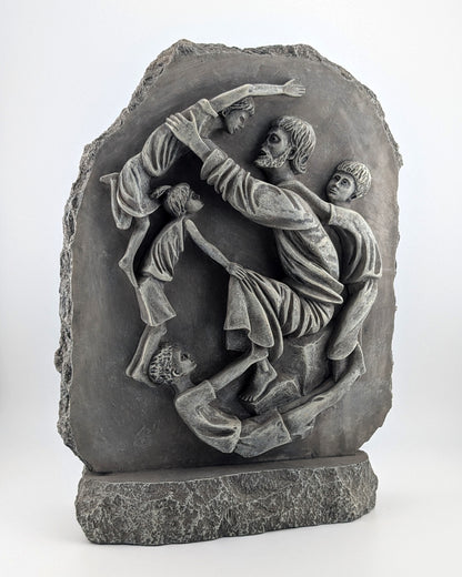 Stone sculpture depicting a scene with people, possibly a historical or mythological event, on a white background.