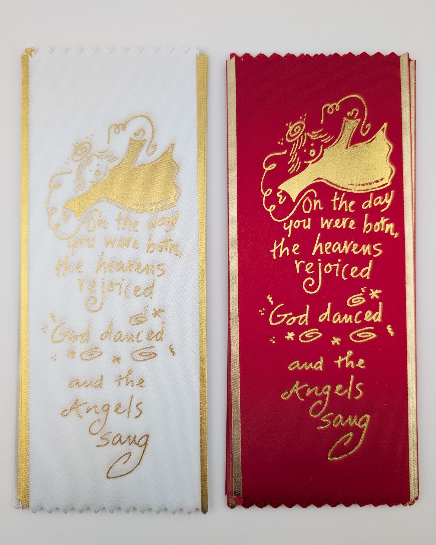 Two bookmarks with gold text on a white and red background