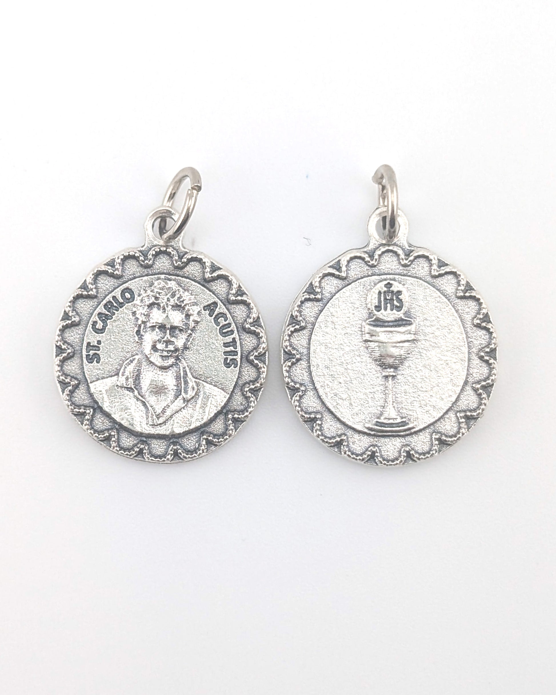 Two silver religious medallions on a white background